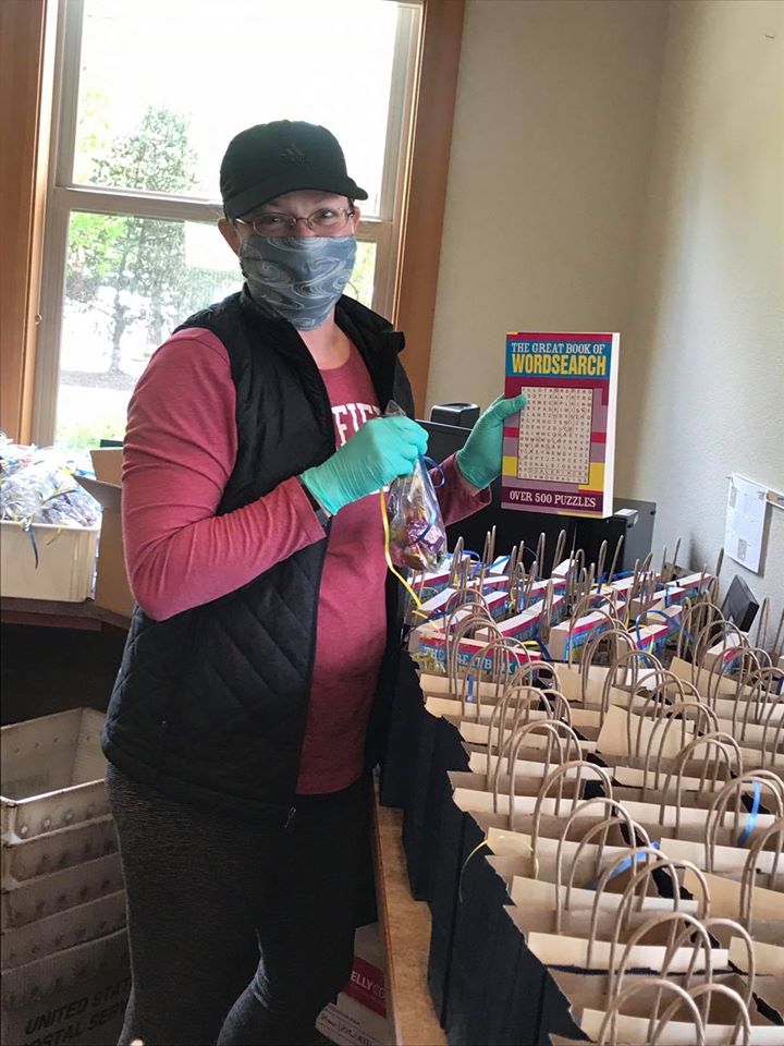 Let the assembly line begin! Sporting my PPE as I stuff the care package gift bags for local delivery. See the USPS bins in the back for carrying the boxes to the post office and the large pile of candy bags?